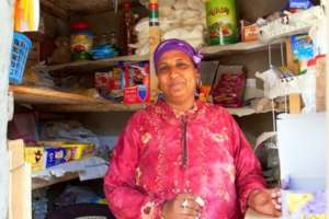 A B'edaya mother stands in front of her store