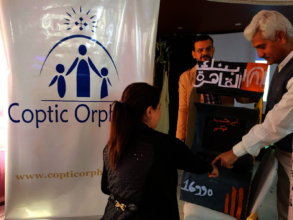 A mother in Baseeta practices using her ATM card