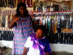 Glory at her Salon styling her customer's hair.