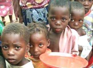 Children receiving porridge with moringa powder.