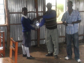 A student receiving a lamp in Makutano