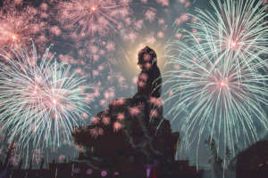 A Buddha statue surrounded by fireworks.