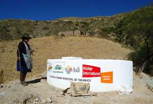 Older Bolivian woman at new community water tank
