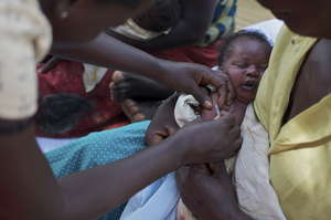 A midwife inoculates a newborn baby at a clinic