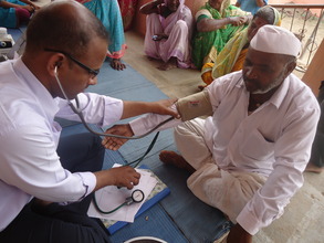 Dr. Reddi taking blood pressure of local farmer