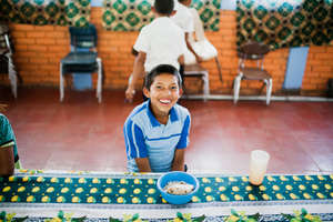 A student enjoys school lunch in Las Sabanas