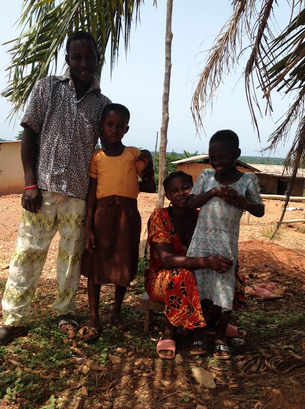 parents and two daughters stand together smiling
