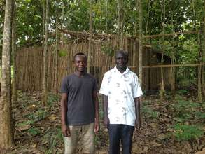 Graduate Samuel (right) in front of cropping house