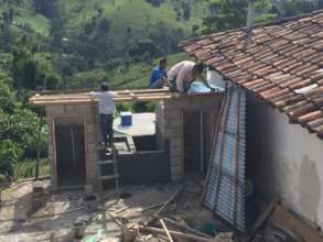 Community members assist with building latrines
