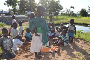 Children wondering around the water well