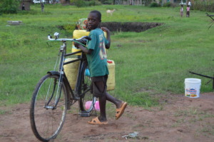 A Child Scambling to Help A Family with Water