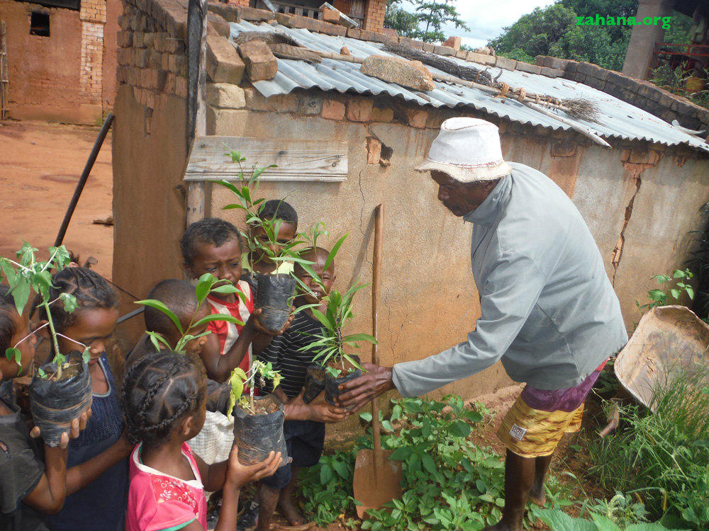 Our gardner Jean planting tress with children