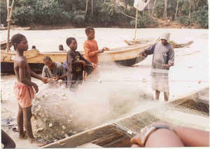 Children mending fishing nets at the beach