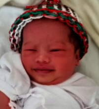 Healthy baby wearing a Christmas hat!