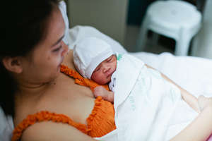 Newborn tenderly held by mother