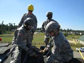 Soldiers install shingles on the Smith home