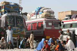 Afghan refugees wait to return home by bus.