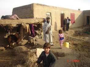 A returnee family outside their new home