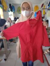 Rahmah with the clothes that she made