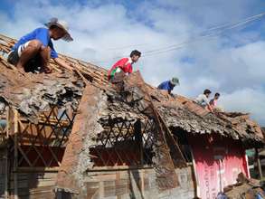 Residents building the new roof we helped provide