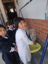 Girl using the hand washing station at a school