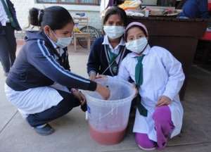 Students of a local school producing soap