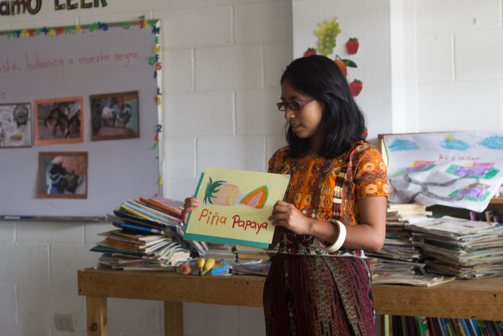 Isabela, tutor, reading a book to the students