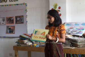 Isabela, tutor, reading a book to the students