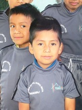 A student in Panabaj wears his new uniform